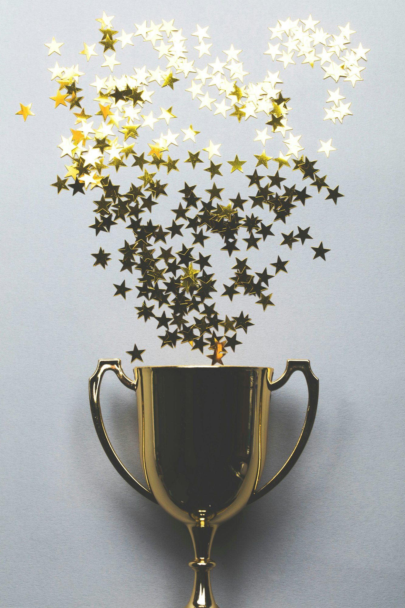 Winners gold trophy with golden star confetti